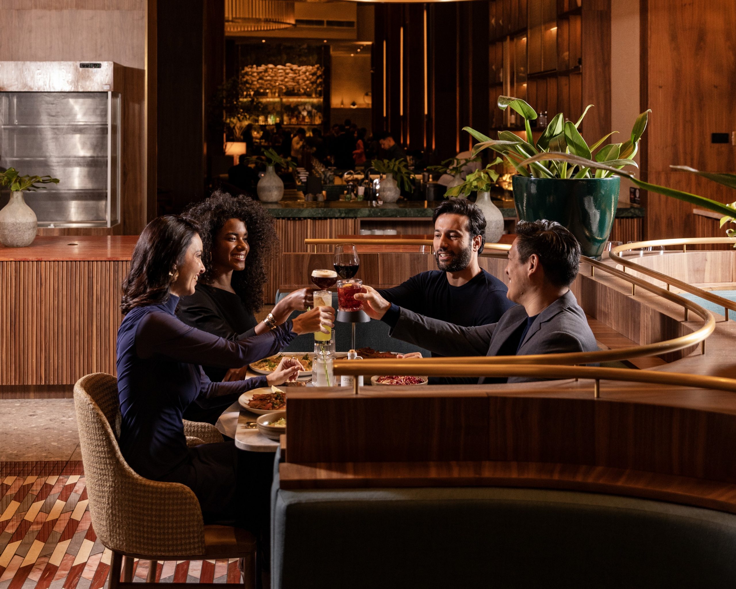Grupo de amigos reunidos em uma mesa de restaurante de luxo realizando um brinde